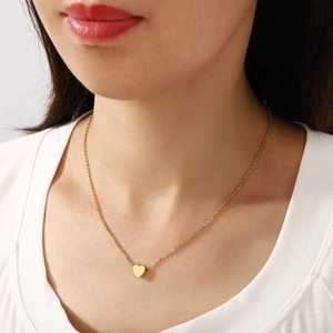 Elegant gold-plated stainless steel necklace with heart pendant on female model