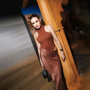 Detail of caramel silk dress featuring a halter neckline and waist cut-out design
