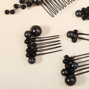Macro detail of black bridal hair comb set with metallic wires and glossy beads