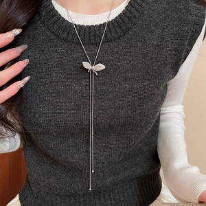 Detail of silver butterfly pendant with mother of pearl and diamonds on long chain