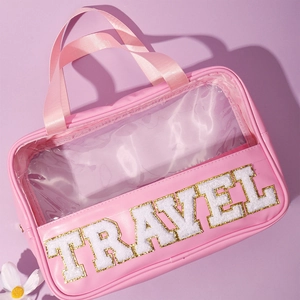 Pink PVC and PU travel makeup bag with gold glitter letters spelling out TRAVEL