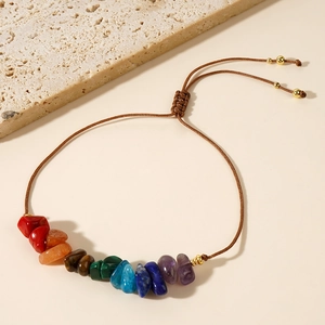 Detailed view of handmade wax thread bracelet with natural colorful stones and gold beads