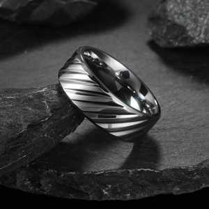 Anello da uomo in acciaio al titanio testurizzato con scanalature diagonali su ardesia