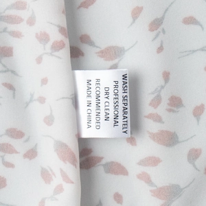 Détail macro de l'étiquette de lavage et du tissu floral sur une robe d'été