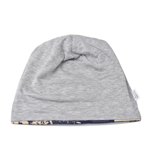 Detailed view of grey knitted beanie featuring floral letter print lining and woven label