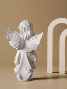 Vista trasera detallada de una figura de ángel de resina blanca con alas y túnica fluida