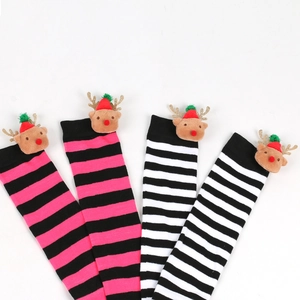 Detail view of striped Christmas stockings with plush reindeer dolls and holiday hats