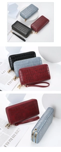 Detail of crocodile pattern long wallets in black, blue, and red with double zippers
