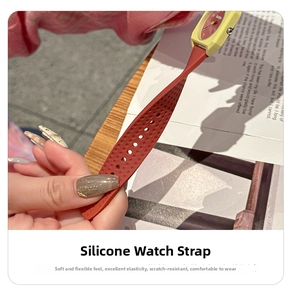 Close-up of flexible brick red silicone watch strap with adjustable holes on yellow case