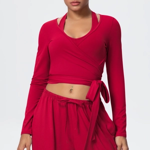 Detail of red V-neck cross wrap long sleeve crop top and drawstring wide leg yoga pants