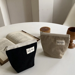Corduroy makeup bags in beige and black with 'Big star & little moon' patch on a table