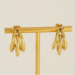 Close-up of 18K gold-plated multilayer earrings displayed on a professional jewelry stand