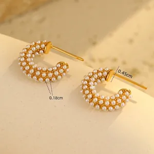Detail of C-shaped 18K gold-plated stainless steel earrings with tiny inlaid white pearls