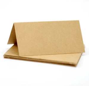 Detailed view of folded brown kraft paper place cards on a clean white background
