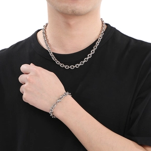 Ensemble collier et bracelet en acier inoxydable poli présenté sur modèle en argent
