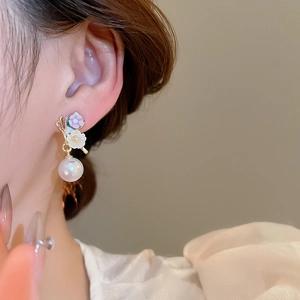 Détail de boucles d'oreilles élégantes avec fleurs et perles portées par un mannequin