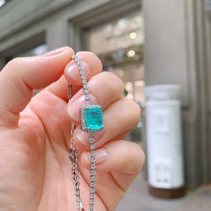 Close-up of a tennis bracelet featuring an emerald-cut turquoise zircon stone detail