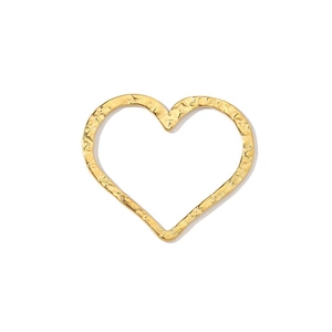 Macro view of a gold heart-shaped titanium steel pendant with unique hammered texture