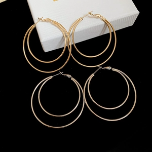 Detailed view of glossy double layer gold earrings on a premium jewelry display box