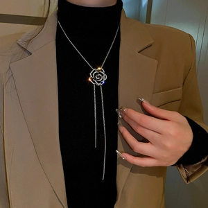 Détail du collier à pampilles camélia en zircon porté par un mannequin sur un pull