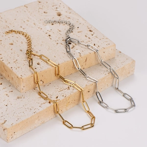 Gold and silver stainless steel paperclip chain anklets on elegant stone display