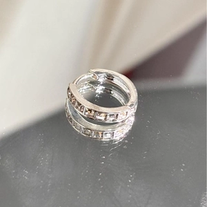 Elegant silver round hoop earrings with sparkling pavé zircons on a reflective surface