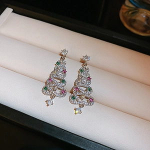 Detailed view of silver Christmas tree earrings with colorful cubic zirconia on foam