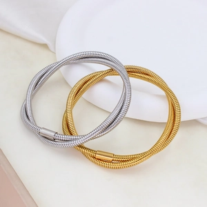 Macro shot of gold and silver snake texture elastic bracelets on a white tray