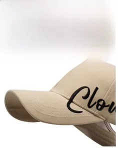 Macro shot of curved brim and black embroidered lettering on light khaki sun hat