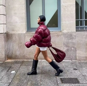 Detail of high-neck glossy burgundy puffer jacket in stylish street wear style