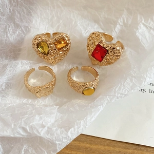Detailed shot of four vintage gold alloy rings with lava textures and colorful resin gems