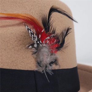 Dettaglio cappello in feltro marrone con nastro grosgrain nero e piume colorate vivaci
