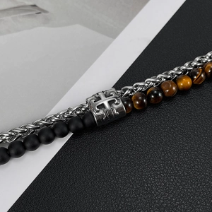 Detail of double-layer stainless steel bracelet with tiger eye beads and cross charm