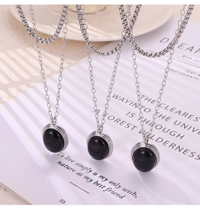 Detailed view of British style stainless steel layered necklaces with black enamel charms