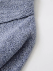 Macro view showing fine knit texture and ribbed cuff detail on light blue polo sweater