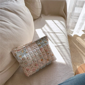 Vista dettagliata del patchwork floreale trapuntato e dell'etichetta sulla borsa in cotone