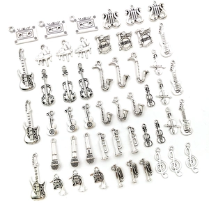 Macro view of antique silver musical instrument charms and pendants on white background