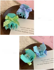 Detail of mint green and blue floral claw clips with checkered fabric bows on wood