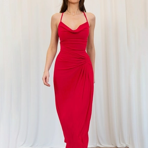 Detail of red cowl neck evening dress showing elegant draped fabric and waist pleats