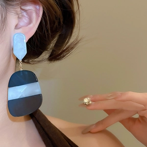 Detail of geometric acetate dangle earrings with marble texture on model view