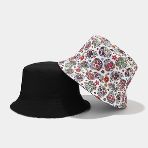 Dettaglio del cappello reversibile con lato nero e stampa colorata di teschi e fiori
