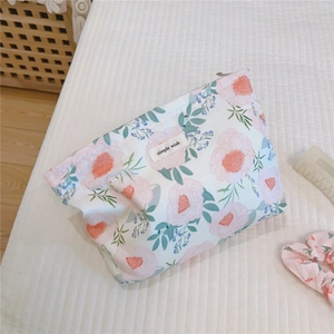 Close-up of floral cotton makeup bag with simple wish label and matching hair accessories