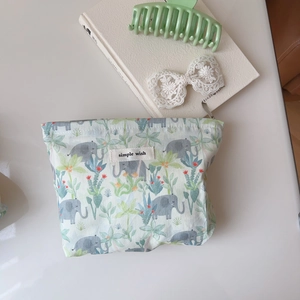Detail of canvas pouch with cute elephant and palm tree prints and simple wish label