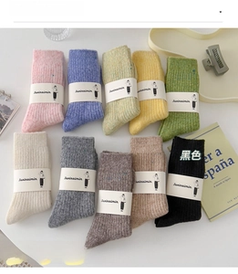 Detailed flat lay of warm wool socks in ten soft colors including pink, green, and cream