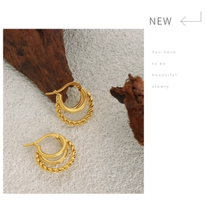 Detail of 18K gold-plated C-shaped triple-layer hoop earrings with twisted rope texture