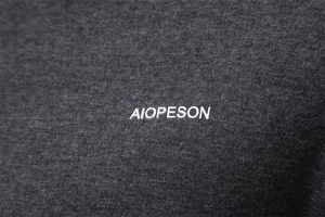 Macro shot of charcoal gray knit fabric with AIOPESON silicone logo and fine texture