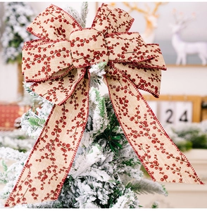 Close-up of linen bow with red berry print on snowy Christmas tree branch