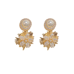Elegant gold fireworks earrings with white pearls and sparkling zircons on white background