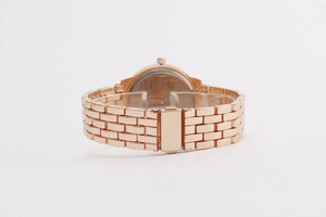 Detailed shot of rose gold metal link strap and folding clasp on a women's watch