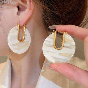 Gros plan de boucles d'oreilles en U plaquées or 18k avec disque en acétate marbré